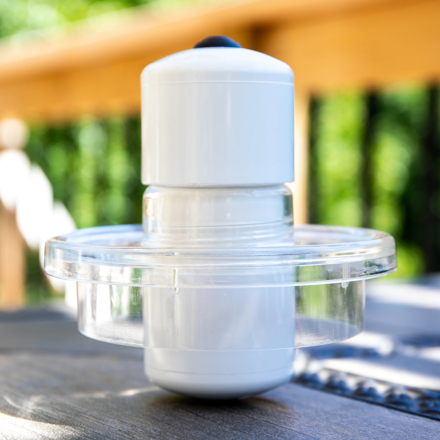 Pictured is the activator piece used for the MRET Water Activator sitting on a table outside on a sunny day.