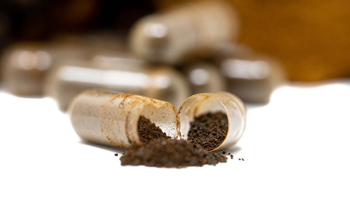 Open capsule of chaga, showing contents as they spill onto the table