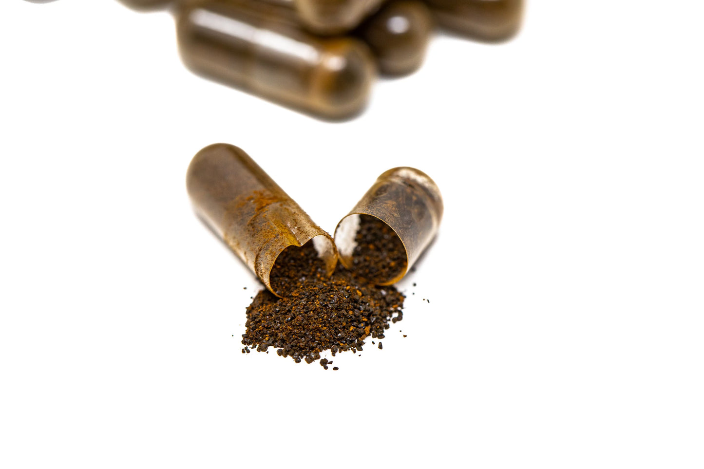 Open capsule of chaga, showing contents as they spill onto the table