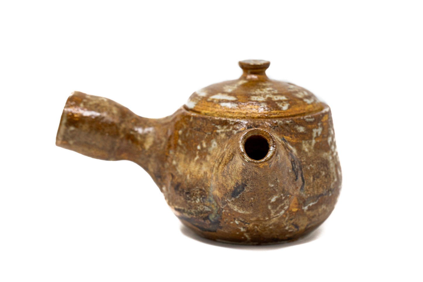 A burnt orange tea pot photographed on a white background