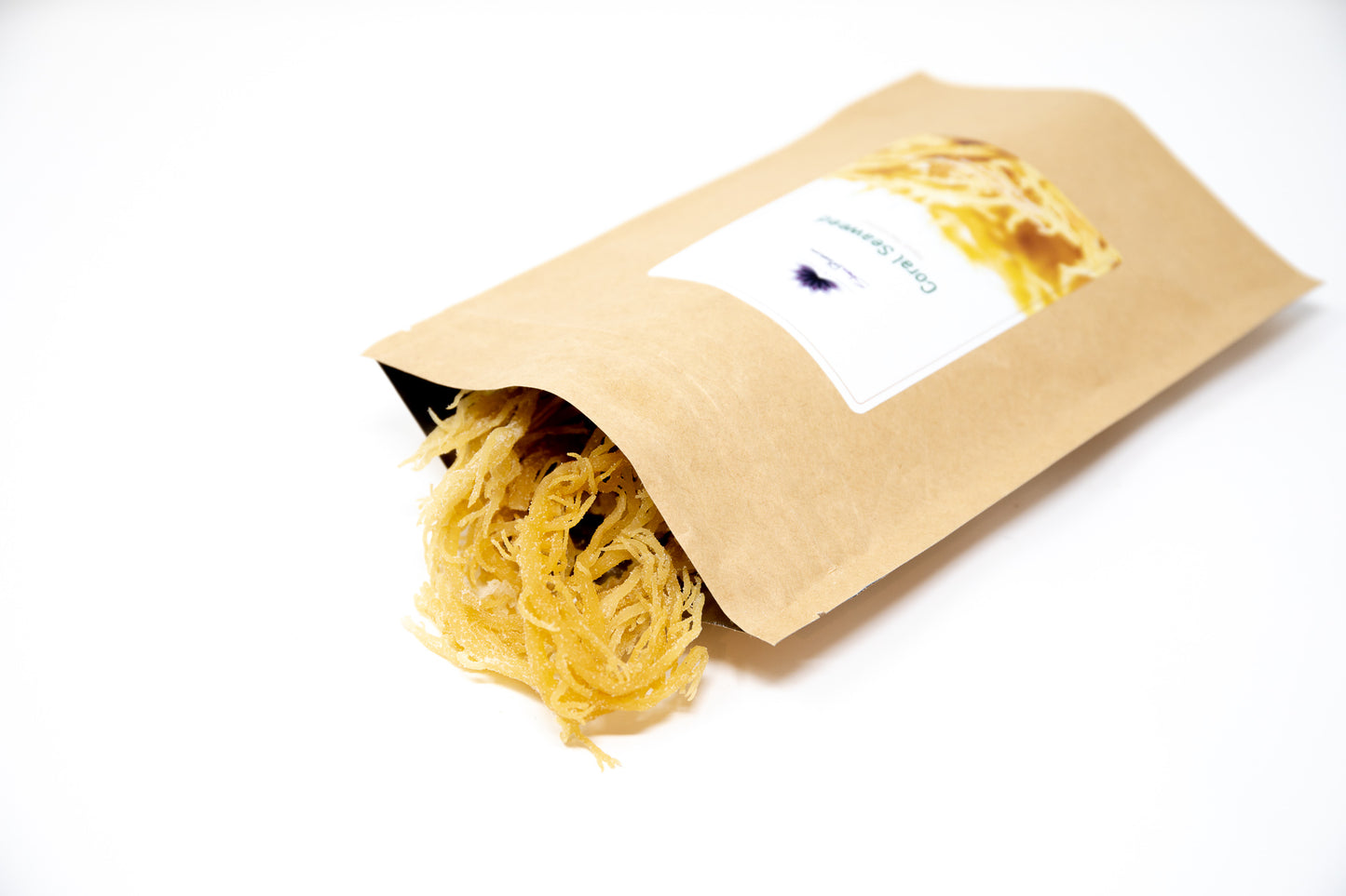 This image shows a bag of Shen Blossom's hand harvested Young Coral Seaweed being poured onto a white background