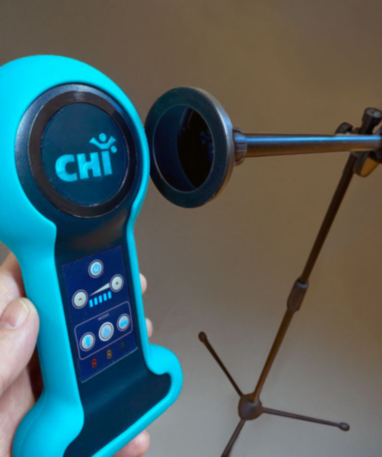 
                  
                    A person holding a Chi Palm up to the magnetic mount of their stand
                  
                